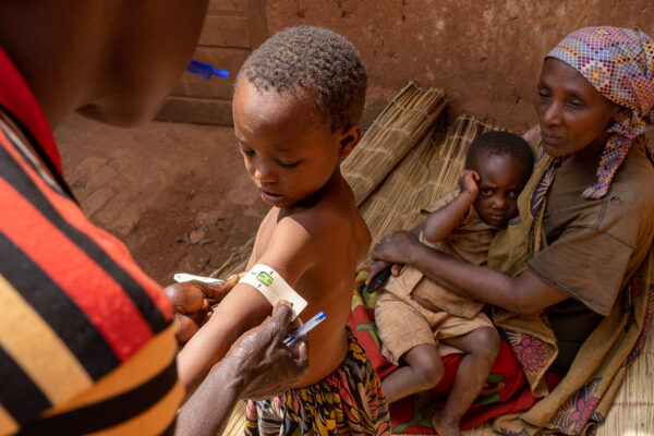 Visite d'une ASC dans un ménage.
Mesure (à la moitié du bras) du périmetre brachiale, indicateur de la malnutrition.
La couleur lue sur la règle indique l'éventuelle malnutrition de l'enfant.
Si c'est rouge, il s'agit de malnutrition sévère, l'ASC l'indique au centre de santé.